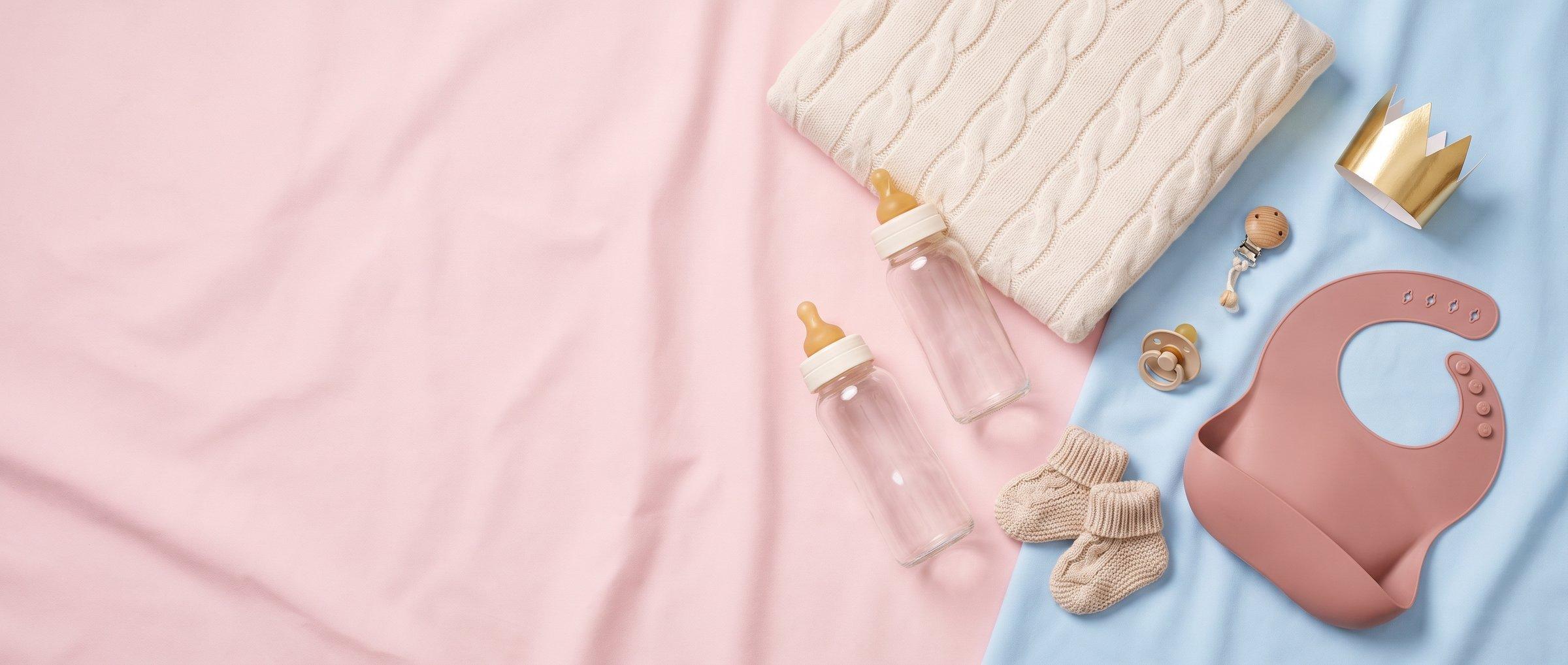Newborn essentials laid out on a pastel background